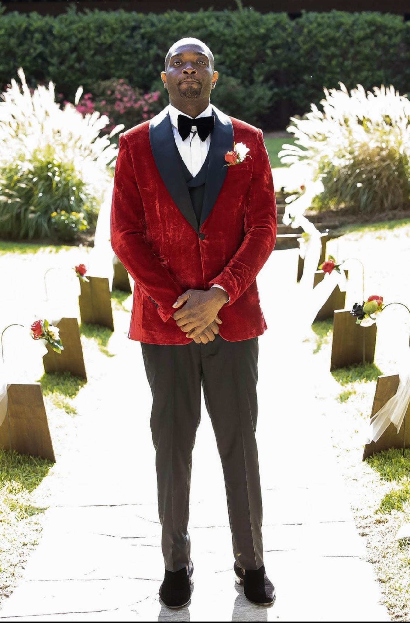 Custom red velvet tuxedo styled for a garden wedding